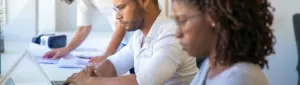 Trabalho terceirizado: fotografia de três pessoas trabalhando. Algumas estão usando o notebook.
