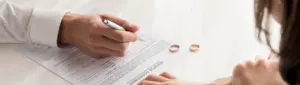 Partilha de imóvel financiado no divórcio: fotografia de um casal assinando o documento de divórcio.