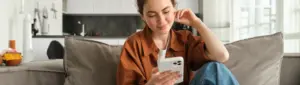 Programa de Pontos Itaú: fotografia de uma mulher usando o celular.