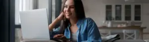 Boa Vista Score: fotografia de uma mulher sorrindo enquanto olha para o computador.