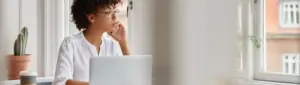 Score para financiamento: fotografia de uma mulher usando o computador e falando ao telefone.