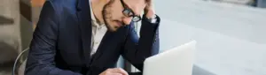 Meu score baixou do nada: fotografia de homem com expressão de preocupação olhando para o computador.