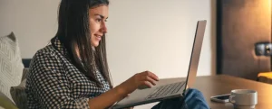 Negociar Mercado Pago: fotografia de mulher usando o computador em casa.