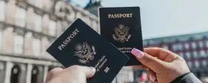 Para tirar passaporte precisa ter nome limpo: fotografia com foco nas mãos de duas pessoas segurando seus passaportes.