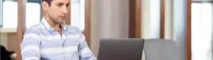 Como consultar dívidas no CNPJ: fotografia de um homem utilizando o computador.