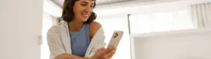 Cielo negocie: fotografia de mulher sorrindo enquanto olha para o celular.