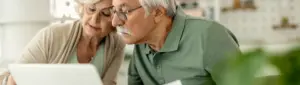 Teto da aposentadoria: fotografia de um casal de idosos analisando documentos.
