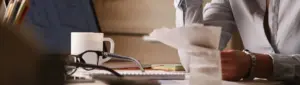 Como sair do endividamento: fotografia de uma pessoa analisando contas em uma mesa.