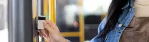 Desconto de passagem no salário: fotografia de uma pessoa passando vale-transporte no ônibus.