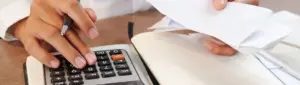 Posso pagar o IPVA no cartão de crédito: fotografia de uma pessoa usando a calculadora.