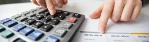Reajuste salarial: fotografia de uma pessoa usando a calculadora.